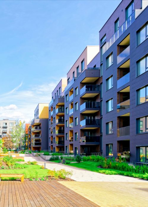 Apartment in residential building exterior. Housing structure at blue modern house of Europe. Rental home in city district on summer. Wall and glass high architecture for business property investment.