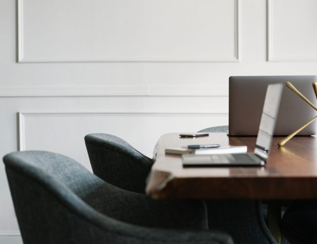 Laptop on a wooden table in a meeting room